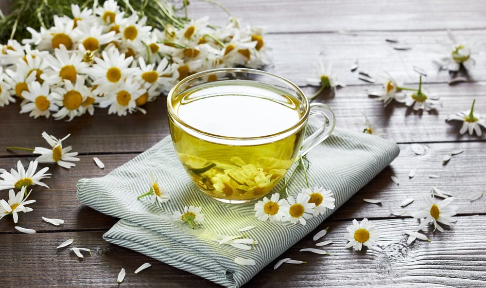 Chamomile,Herbal,Tea,With,Flower,Buds,Nearby,On,Wooden,Table